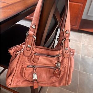 B. Makowsky soft leather shoulder bag with dual straps and front zip pockets.